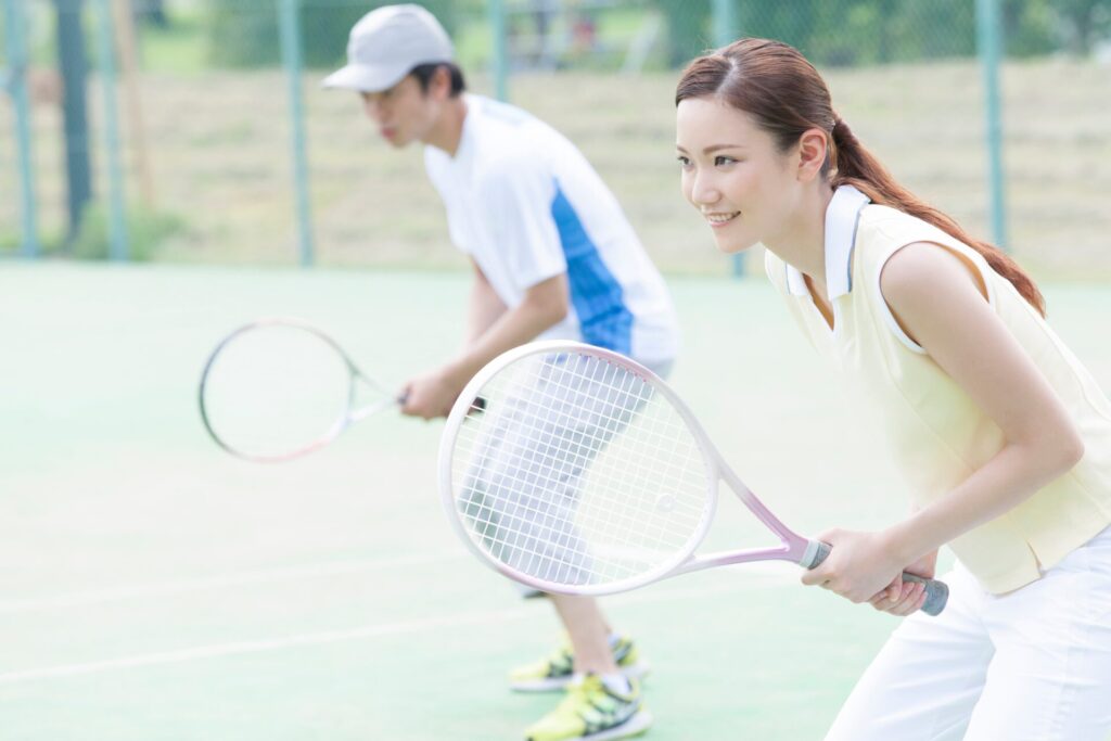 男女がテニスをプレイする写真
